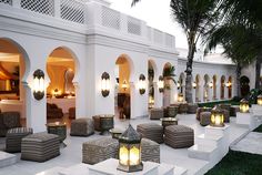 an outdoor seating area with candles lit up on the steps and palm trees in the background