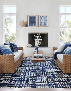 a living room with wicker furniture and blue accents on the walls, along with large windows