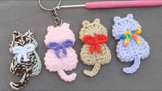 four crocheted keychains with cats on them