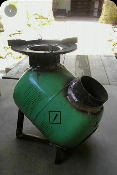 a green propane tank sitting on top of a cement floor next to a fire hydrant