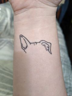 a small tattoo on the wrist of a woman's left arm, depicting two birds