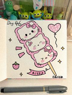 a hello kitty drawing on a piece of paper next to a pen