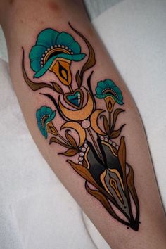 a person with a tattoo on their arm holding a pair of scissors and some flowers