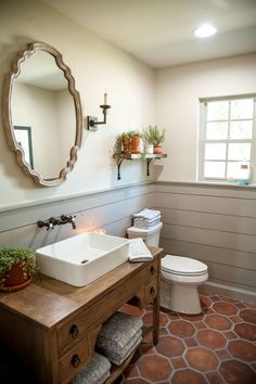 a bathroom with a sink, toilet and mirror