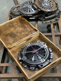 a wooden box with a clock inside of it on top of some sort of wheels