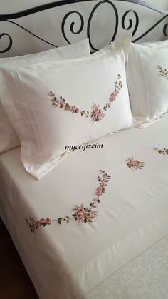 a bed with white sheets and pink flowers on it