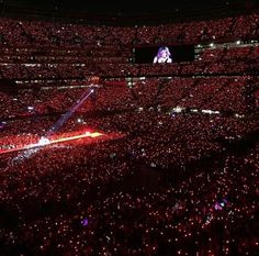 a large stadium filled with lots of red lights and people sitting in the bleachers