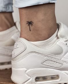 a small palm tree tattoo on the ankle