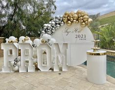 a large sign that says prom with balloons on it and some decorations around the letters