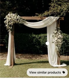 an outdoor wedding ceremony setup with white flowers and draping on the arbors