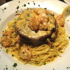 a white plate topped with pasta and shrimp