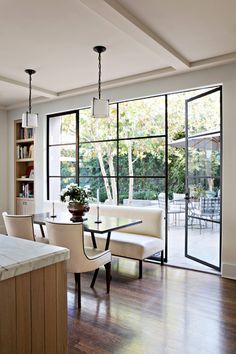 an image of a living room and dining room with pictures on the wall above it