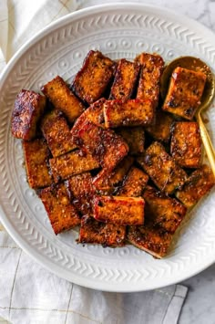 tofu on a white plate with a spoon