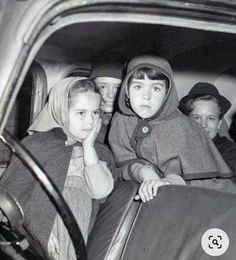 an old black and white photo of children in a car