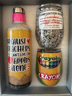 two jars are sitting in a box with labels on them and one is filled with crayons