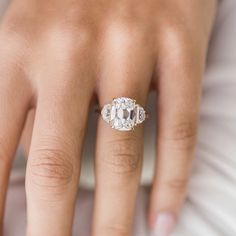 a woman's hand with an engagement ring on her finger, showing the center stone