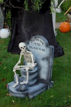 a skeleton sitting on top of a tombstone