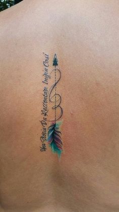 the back of a woman's shoulder with an arrow and quote tattoo on it