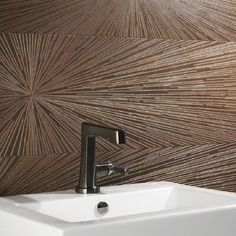 a white sink sitting under a faucet next to a brown wallpapered wall