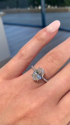 a woman's hand with a ring on it and a diamond in the middle