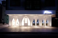 an empty building lit up at night with lights on the windows and doors in front