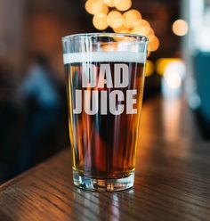 a shot glass sitting on top of a table with the word dad juice printed on it