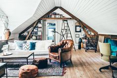 a living room filled with furniture and lots of books on top of a hard wood floor