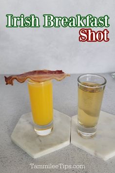 two glasses filled with orange juice and bacon sitting on top of marble coasters next to each other