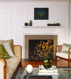 a living room filled with furniture and a fire place under a painting on the wall