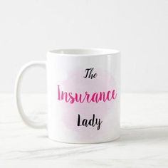 a white coffee mug with the words the insurance lady on it and pink watercolor paint