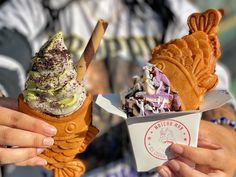 two people holding ice cream cones in their hands