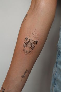 a person's arm with a tattoo on it that has a leopard head and words