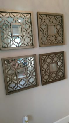 three decorative mirrors mounted on the wall above a toilet