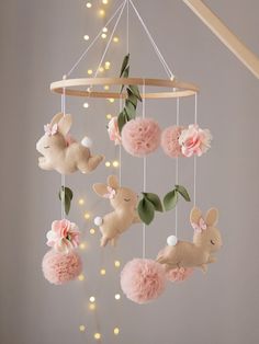 a baby crib mobile with pink pom poms hanging from it's sides