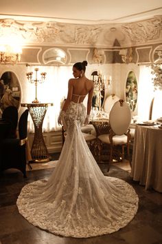 the back of a woman's wedding dress in a room with chandeliers