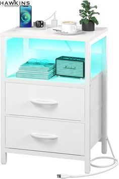 a white night stand with two drawers and a phone on it's top shelf