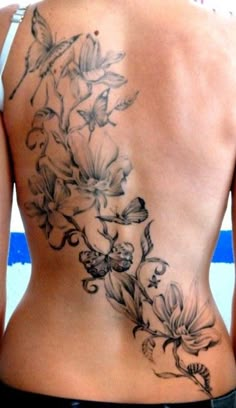 the back of a woman's body with flowers on her lower back and side