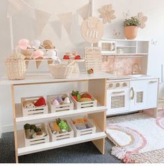 a play kitchen with toys and food on the shelves in front of it that says we eat