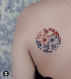 the back of a woman's shoulder with flowers painted on her left arm and chest