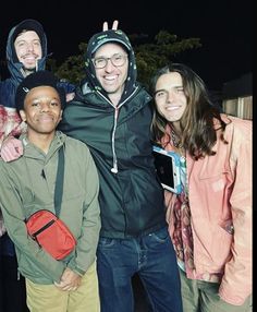 a group of people standing next to each other in front of a building at night