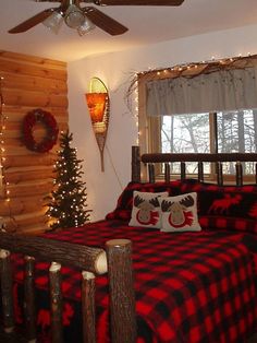 a bedroom decorated for christmas with red and black plaid bedding