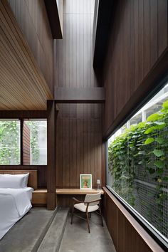 a bedroom with wood paneling and plants on the wall above it, along with a bed