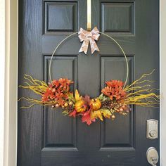 a front door with a wreath and candles on it, decorated with autumn foliages