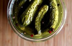 pickled cucumbers in a glass jar on a wooden table