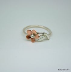 Copper Daisy ring Sweet and simple this lovely ring is a must for everybody's  jewellery box.  Suitable for all occasions. The daisy has been hand saw pierced from copper then lightly domed and completed with a silver bead and lightly brushed finish. From the base of the daisy is a silver stem with single silver leaf. The band is 1.5mm. wide with a lightly polished finish The daisy measures 8.5mm. in diameter. UK finger sizes  J to T Other sizes on request  All my jewellery comes in a presentation gift box.  All my designs are hand made and no two are exactly the same.   Thank you for your time. Please note that international shipping fees do not include possible custom charges for your country and you will be solely responsible for payment of these charges.  We are required by law to full Rose Gold Sterling Silver Flower Rings, Handmade Rose Gold Sterling Silver Stackable Rings, Handmade Sterling Silver Stackable Rings In Rose Gold, Handmade Delicate Flower Ring, Handmade Flower-shaped Promise Ring, Handmade Flower Shaped Promise Ring, Dainty Nickel-free Flower Ring For Wedding, Handmade Rose Gold Flower Ring, Handmade Dainty Open Flower Ring