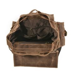 a brown leather bag is open and sitting on a white surface with the bottom compartment closed