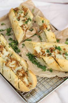 four hot dogs with toppings sit on a cooling rack