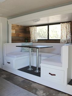 a table and bench in the corner of a room