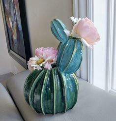 a vase with flowers in it sitting on a couch