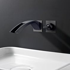 a white sink sitting under a faucet next to a wall mounted soap dispenser